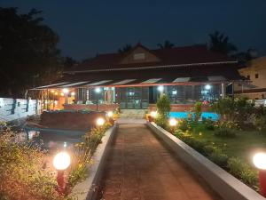 a house with a swimming pool at night at Beach Nest in Kannur