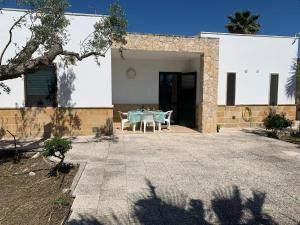 a house with a table in front of it at Tenuta Punta della Suina in Gallipoli