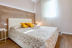 a bedroom with a white bed with yellow pillows and a window at Le Ville della Romantica in Manerba del Garda +43 photos