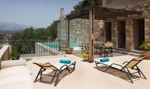 patio z 2 krzesłami i basenem w obiekcie Istron Luxury Villas w mieście Istro