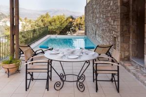 uma mesa e cadeiras num pátio com piscina em Istron Luxury Villas em Istro