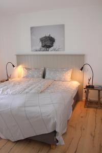 a bedroom with a large white bed with two lamps at Fine Home in Timmendorfer Strand