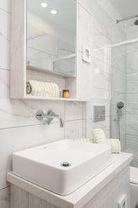 a white bathroom with a sink and a shower at Niki Mountain House in Kamariótis +37 photos