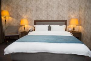 En eller flere senger på et rom på Macara Sheki City Hotel