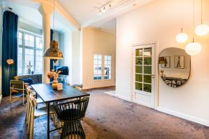 a dining room with a table and chairs and a mirror at The Citadel Apartments by Daniel&Jacob's in Copenhagen