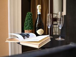 un tavolo con libri e una bottiglia di vino e bicchieri di Kuprin Hotel a Odessa