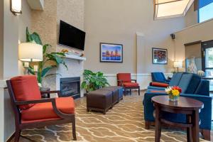 a living room with chairs and a fireplace at Comfort Suites Mobile East Bay in Daphne