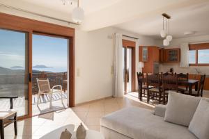 a living room with a couch and a dining room at Triopetra Luxury Villas Panagia in Triopetra