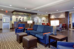 eine Hotellobby mit einem blauen Sofa und Stühlen in der Unterkunft Comfort Inn & Suites Sidney I-80 in Sidney