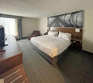 a hotel room with a bed and a television at Clarion Pointe Hopkinsville near The Bruce Convention Center in Hopkinsville