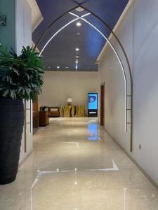 a lobby with a potted plant and a television at Luxury Aparthotel Prive in Dubai +53 photos