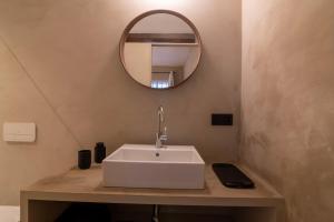 La salle de bains est pourvue d'un lavabo blanc et d'un miroir. dans l'établissement Private en-suite room in the heart of Le Sablon, à Bruxelles