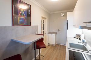 a small kitchen with a counter and a sink at Strandhaus Helene in Wenningstedt +18 photos