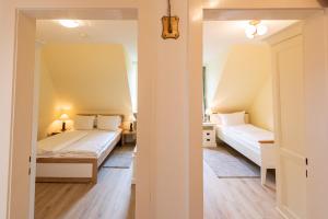 a small bedroom with two beds and a hallway at Strandhaus Helene in Wenningstedt