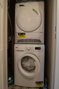 two machines are stacked on top of a washing machine at Private en-suite room in the heart of Le Sablon in Brussels