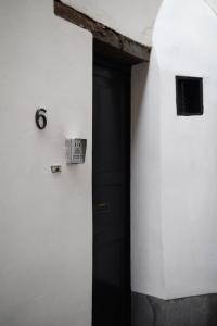 une porte noire dans un mur blanc avec un numéro 6 dans l'établissement Private en-suite room in the heart of Le Sablon, à Bruxelles