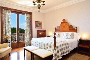a bedroom with a large bed and a balcony at Hostal de la Gavina GL - The Leading Hotels of the World in S'Agaro