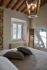 1 dormitorio con 1 cama con 2 almohadas en Bolgheri Wine Suite, en Bolgheri