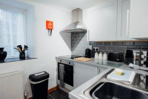 テンビーにあるThe Bakehouse - Cosy conversion with Outdoor Saunaのシンクとコンロのあるキッチン トップオーブン +30枚の写真