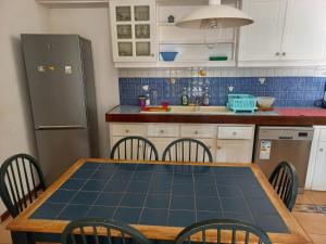 a kitchen with a table and chairs and a refrigerator at Villa L'Oiseau Bleu in Pereybere