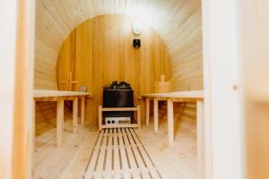 テンビーにあるThe Bakehouse - Cosy conversion with Outdoor Saunaの木製の壁とテーブル2台が備わる客室です。