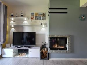 a living room with a tv and a fireplace at Familienferienhaus Lilja - polnische Ostsee in Trzęsacz