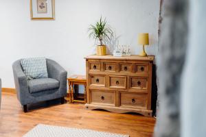 ein Wohnzimmer mit einem Stuhl und einer Kommode in der Unterkunft The Bakehouse - Cosy conversion with Outdoor Sauna in Tenby