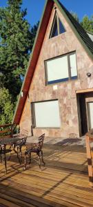 a building with two benches on a wooden deck at El susurro in Villa Pehuenia