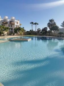 a large pool of water with palm trees and buildings at Modern sea view duplex with parking and aircon in El Médano