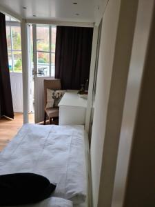 1 dormitorio con cama, escritorio y silla en Waldbahnhof Sauerland en Brilon-Wald