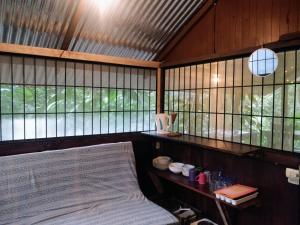 Habitación con cama y algunas ventanas. en Los Mineros Guesthouse, en Dos Brazos