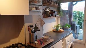 a kitchen with a counter with a sink and a window at Beachhouse Engelbert Studios in Zandvoort