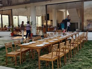 a long wooden table with chairs and people in a building at Hotel Ajanta green restaurant and resort in Phardāpur