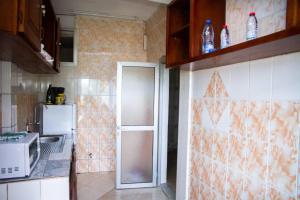 uma cozinha com um frigorífico e um micro-ondas em ABT Apartments Bonapriso-7Mins From Airport em Douala