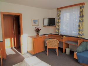 a small room with a desk and a television at Gasthof Lauber in Offenhausen