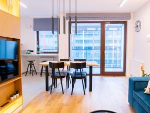 a kitchen and living room with a table and chairs at Hello!Apartments Przy Arkadii in Warsaw