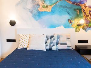 1 dormitorio con 1 cama con una pintura en la pared en Hello!Apartments Przy Arkadii, en Varsovia