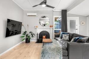 a living room with a couch and a fireplace at Locarno Cottage in Hepburn Springs