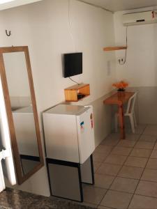 a room with a small refrigerator and a television at Pousada Andorinhas in Santo Amaro