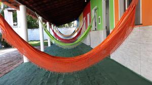 eine orangefarbene Hängematte, die von einem Gebäude hängt in der Unterkunft Pousada Andorinhas in Santo Amaro