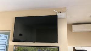 a large flat screen tv hanging on a wall at Casa Ubatuba in Ubatuba