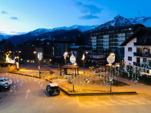 a city with lights in a parking lot at night at Monolocale centro citta' con vista sulle montagne in Sauze dʼOulx