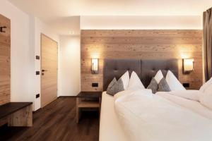 um quarto com uma cama grande e almofadas brancas em Chalet Miriam em Selva di Val Gardena
