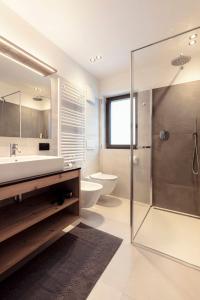 a bathroom with a sink and a shower and a toilet at Chalet Miriam in Selva di Val Gardena