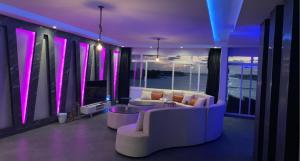 ein Wohnzimmer mit Sofas, einem TV und lila Beleuchtung in der Unterkunft شاليه درة العروس in Durrat Al-Arus