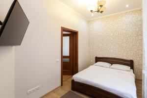 a bedroom with a bed and a flat screen tv at Romari Лесі Українки in Lviv