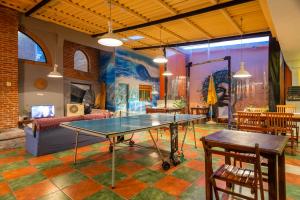 a ping pong table in a room with a couch at Del Barcito Hostel and Suites in Punta del Este