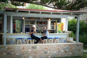 a man and a woman sitting at a bar at Kordistos Hotel in Kefalos