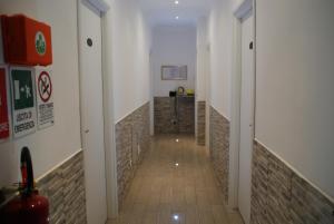 a hallway with white walls and a tile floor at Rome Orange Inn in Rome