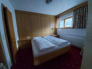 Dormitorio pequeño con cama y ventana en Haus Monika und Haus Claudia, en Mayrhofen